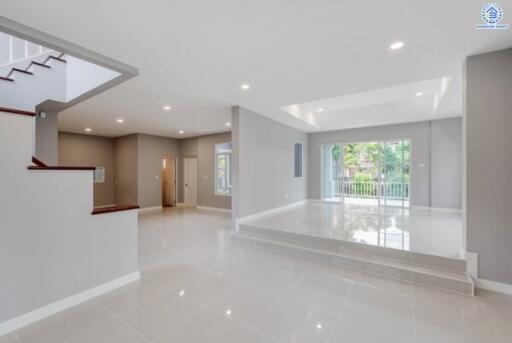 Spacious modern living area with large windows and glossy tiled floor