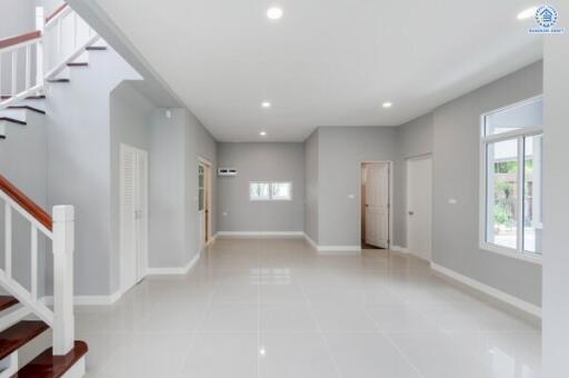 Modern spacious living room with staircase and large windows