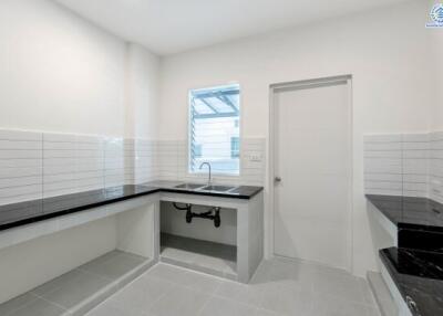 Modern kitchen with black countertops and white tile backsplash