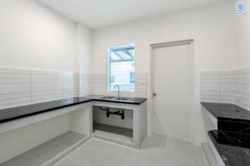 Modern kitchen with black countertops and white tile backsplash