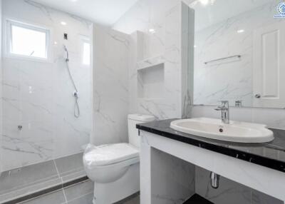 Modern bathroom with white marble tiles and a large mirror