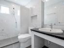 Modern bathroom with white marble tiles and a large mirror