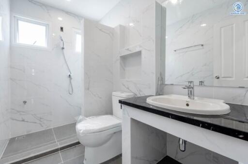 Modern bathroom with white marble tiles and a large mirror