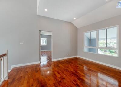 Spacious living room with hardwood floors and large window.