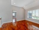 Spacious living room with hardwood floors and large window.