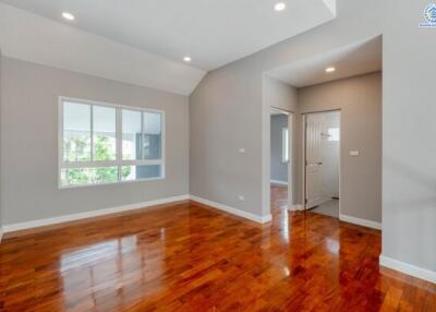 Spacious bedroom with wooden floors and large window