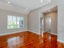 Spacious bedroom with wooden floors and large window