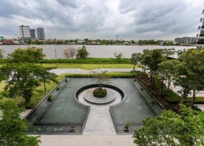 View of water feature and garden area around the property overlooking the river with a view of the city skyline