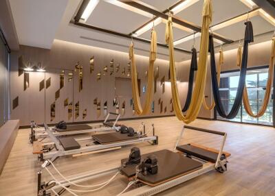 Modern fitness center with aerial yoga hammocks and Pilates equipment