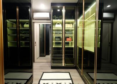 Luxurious walk-in closet with glass doors and ample storage space