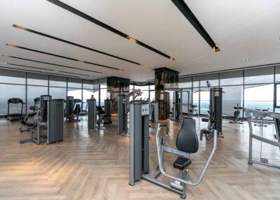 Spacious gym area with modern workout equipment and large windows