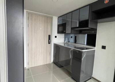 Modern minimalistic kitchen with glossy dark cabinets and tiled floor