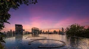 Skyline view from rooftop infinity pool at sunset