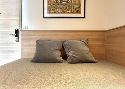 Cozy bedroom with bed, wooden accent walls, and framed artwork