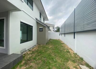 Backyard of a modern house with lawn and tiled pathway