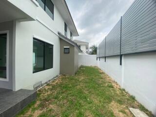 Backyard of a modern house with lawn and tiled pathway