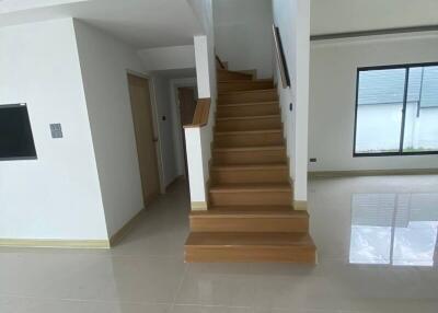 Staircase leading to upper floor with tiled flooring and large window