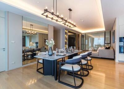 Modern dining area with table set for six, adjacent to a living room