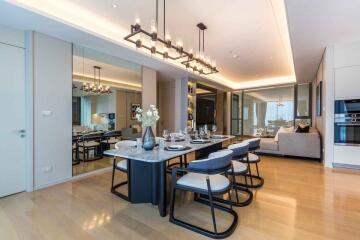 Modern dining area with table set for six, adjacent to a living room