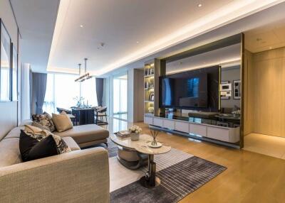 Modern living room with a TV, L-shaped sofa, dining area, and stylish decor.