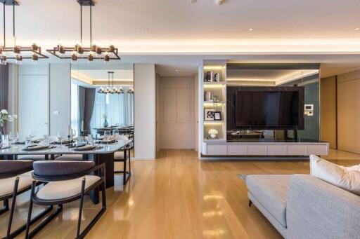 Modern and spacious living area with dining table, TV, and elegant furnishings