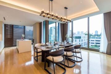 Modern dining room with a view, featuring a long table and large windows.