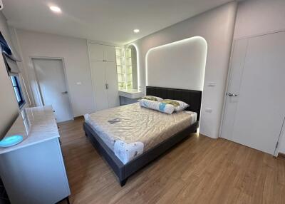 Modern bedroom with wooden floor, double bed, and built-in storage