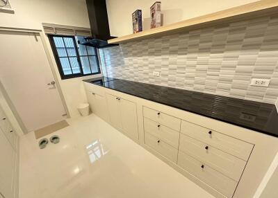 Modern kitchen with white cabinets and black countertop