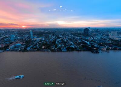 Cityscape view from waterfront with multiple buildings at sunset