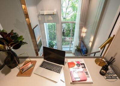 Modern living space with a laptop, books, and a view of the patio