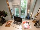 Modern living space with a laptop, books, and a view of the patio