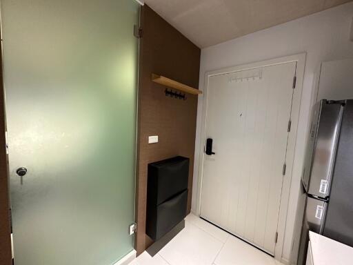 Modern apartment entryway with frosted glass door and white main door