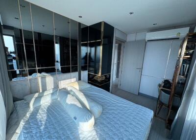 Spacious bedroom with bed, mirrored wall, and modern furnishings