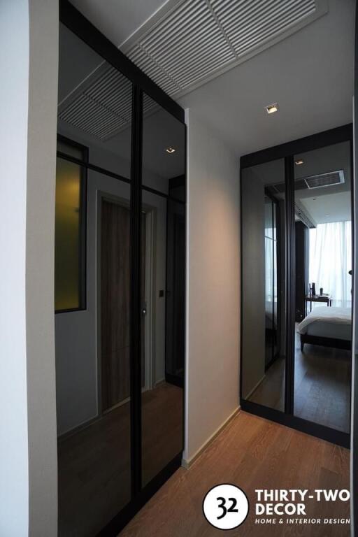 Modern bedroom with large mirrored wardrobe and wooden flooring