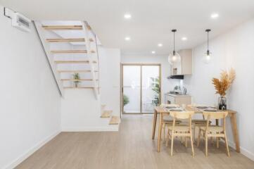 Modern dining area with wooden furniture and staircase