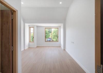 Empty living room with large windows and wooden flooring