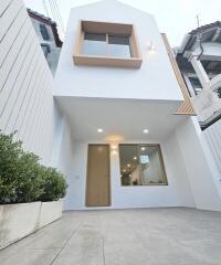 Modern two-story facade with large window and clean white exterior