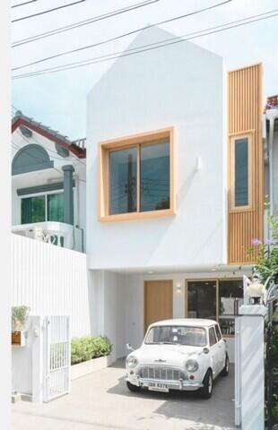 Facade of a modern house with a small vintage car parked outside