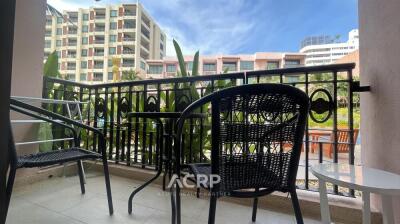 Apartment balcony with table and chairs overlooking urban greenery