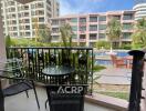 Balcony with outdoor furniture overlooking a pool area