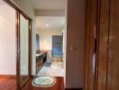 View of a partially open bathroom with wooden cabinets and marble flooring.