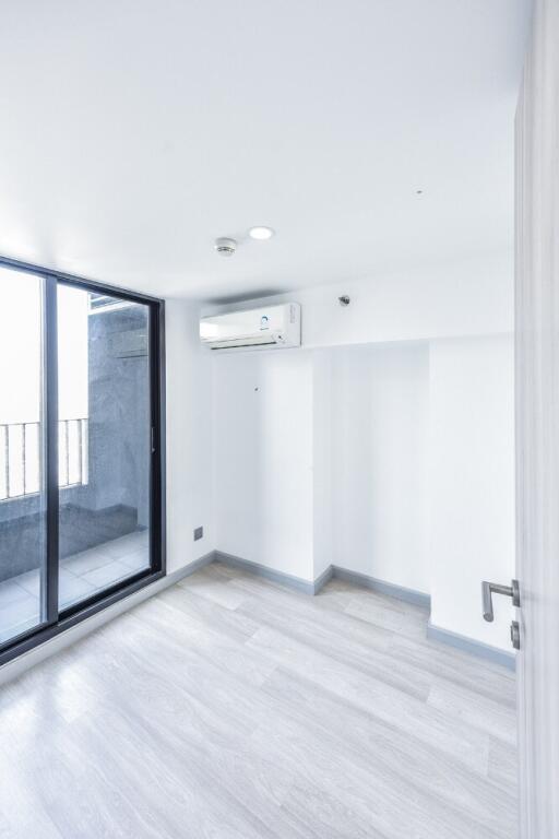 Minimalist bedroom with balcony access and air conditioning