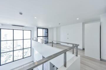 Modern loft area with large windows and railing