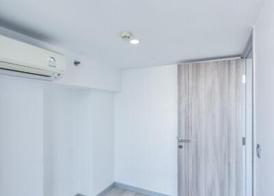 A minimalist bedroom with hardwood flooring and air conditioning