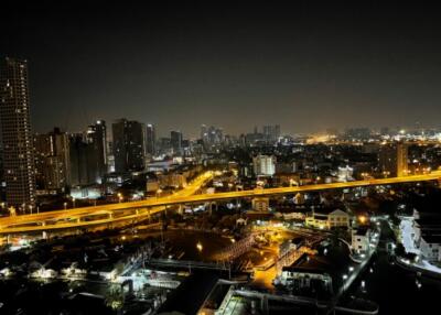 Night view of a city skyline with illuminated buildings and roads