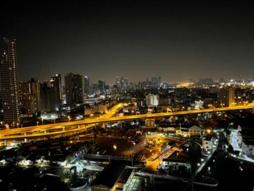 Night view of a city skyline with illuminated buildings and roads