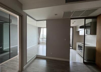 Modern living area with a view of the kitchen and balcony