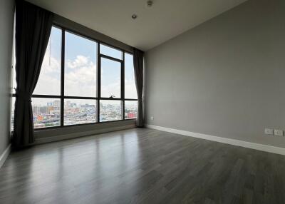 Empty living room with large window and city view