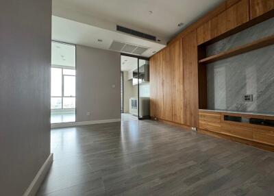 Spacious living area with wooden paneling and open access to kitchen