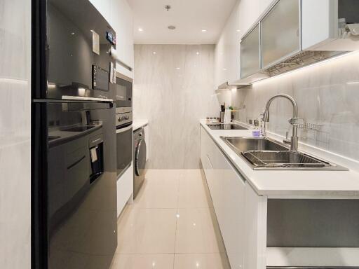 Modern kitchen with white cabinetry and stainless steel appliances